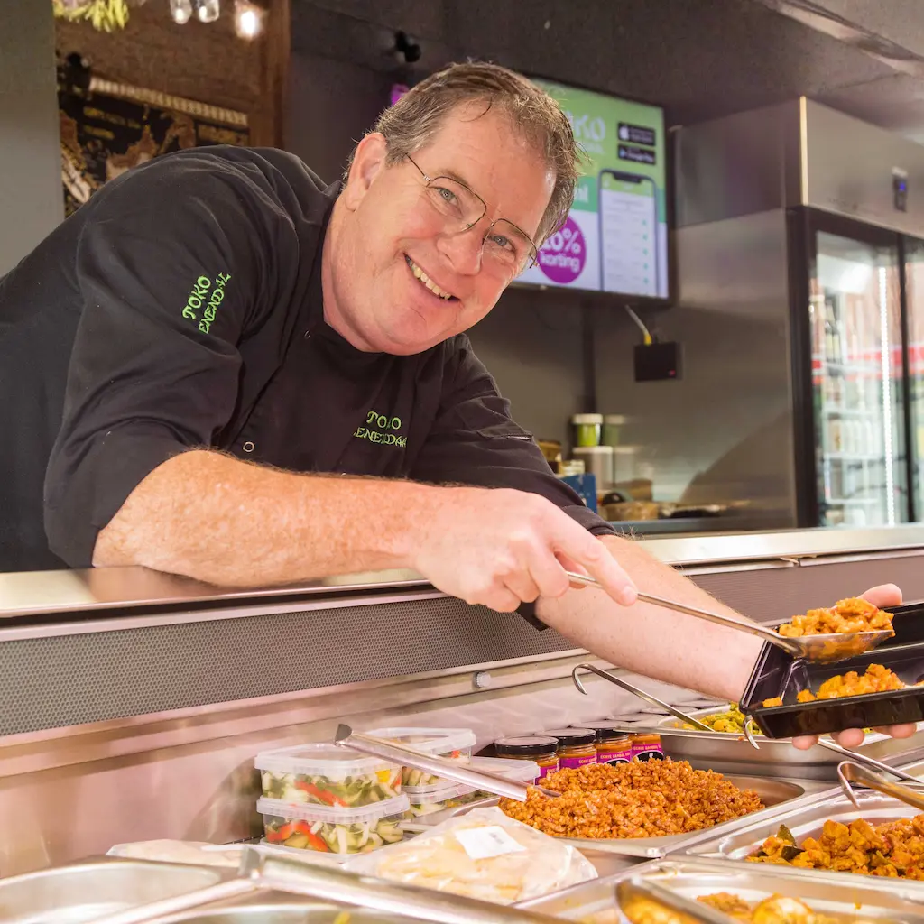 Mark van Tellingen die het heerlijke eten van Toko Veenendaal klaar maakt voor een klant.
